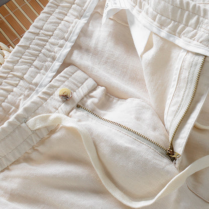 Close-up of beige pants with a zipper and button detail.