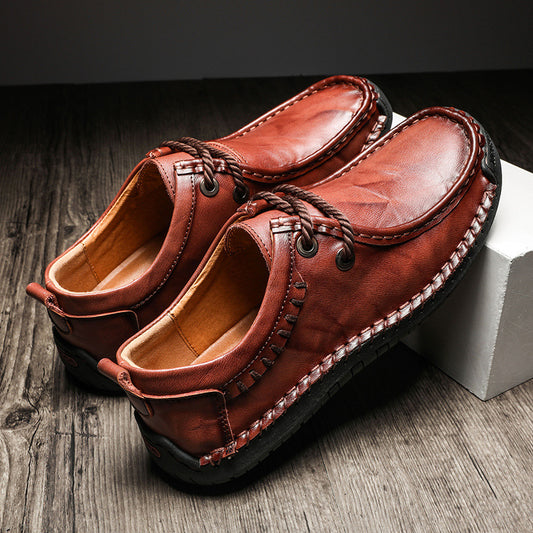 Brown leather shoes with braided laces on a wooden surface
