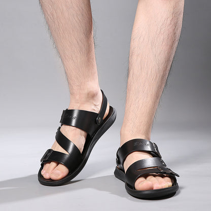 Black sandals worn by a person on a gray background