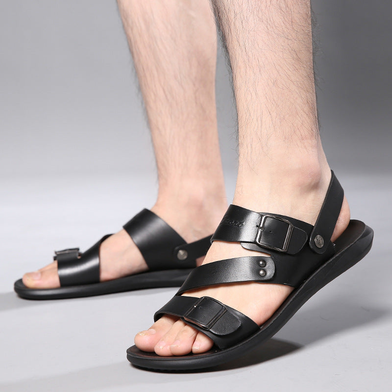Black sandals worn by a person on a gray background