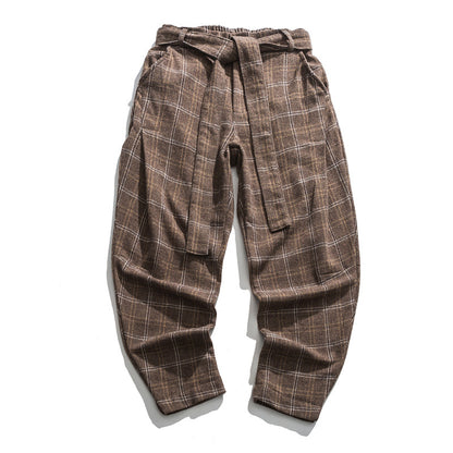 Brown plaid pants with a tie-waist design on a white background