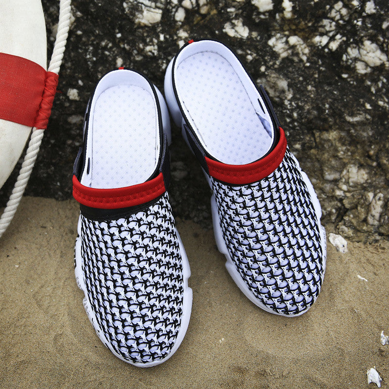 Black and white patterned slippers with red straps on a sandy surface.
