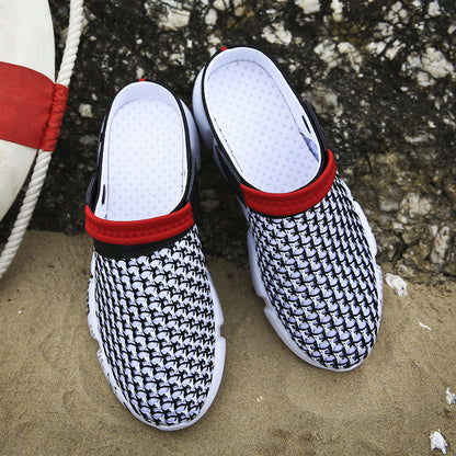 Black and white patterned slippers with red straps on a sandy surface.