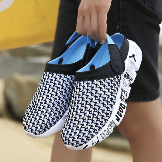Black and white patterned shoes with blue soles held by a person.