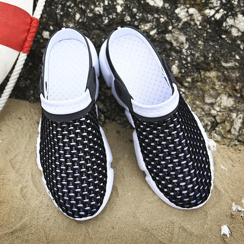 Black and white mesh shoes on a sandy surface with a textured background