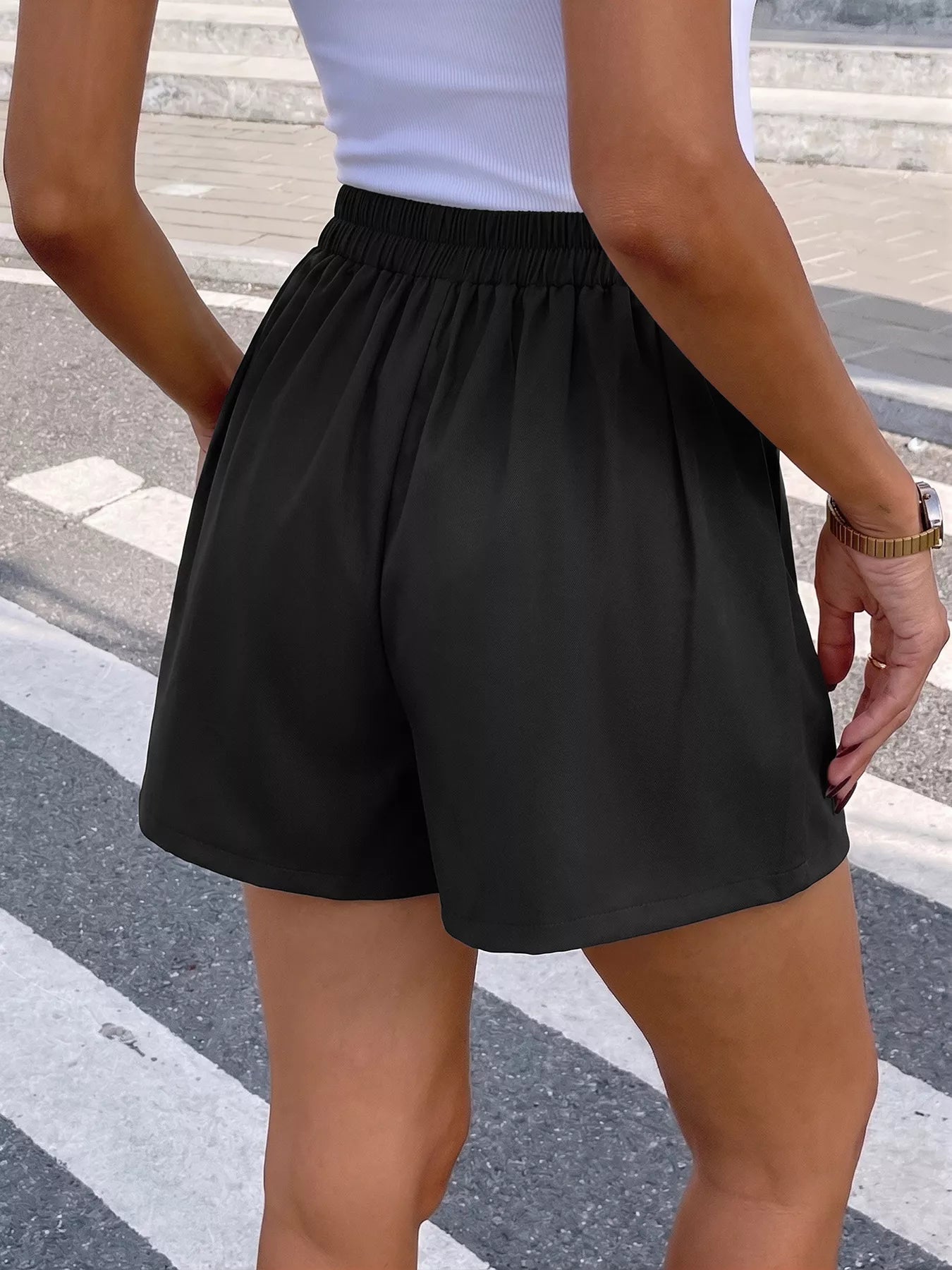 Person wearing black shorts on a street background