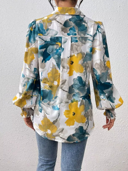 Person wearing a floral-patterned jacket with yellow and blue flowers on a plain background