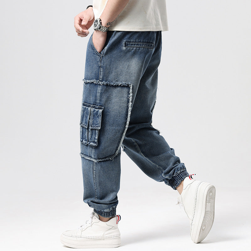 Person wearing blue baggy jeans and white sneakers on a light gray background