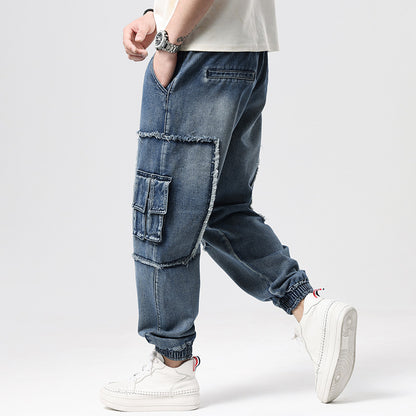 Person wearing blue baggy jeans and white sneakers on a light gray background