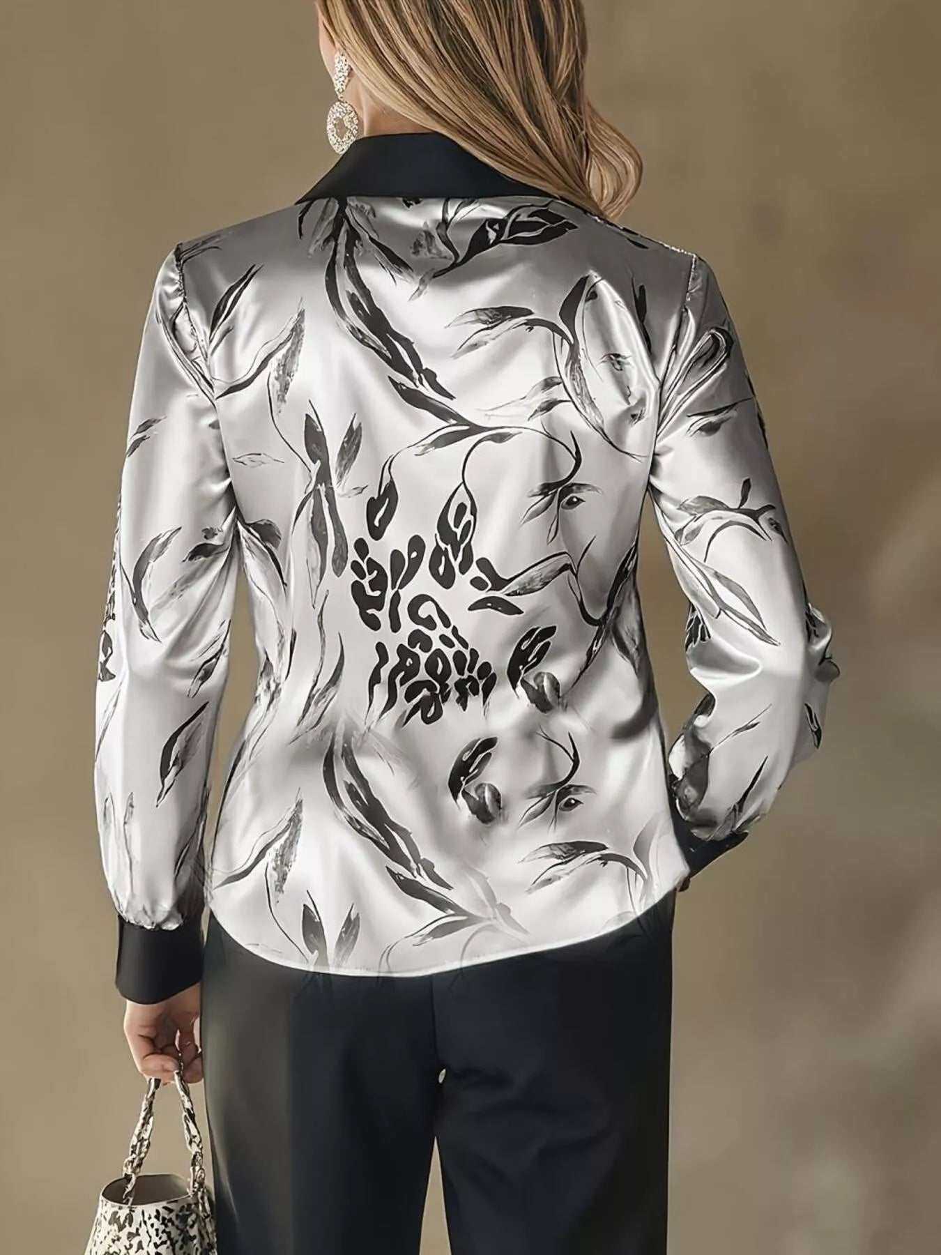 Person wearing a silver floral patterned jacket against a neutral background