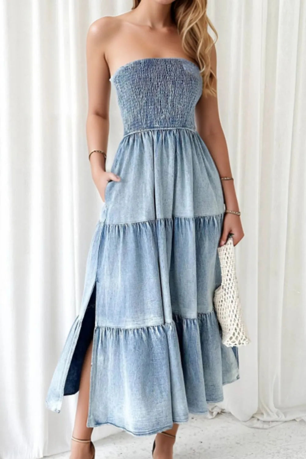 Woman wearing a strapless denim dress with a white background