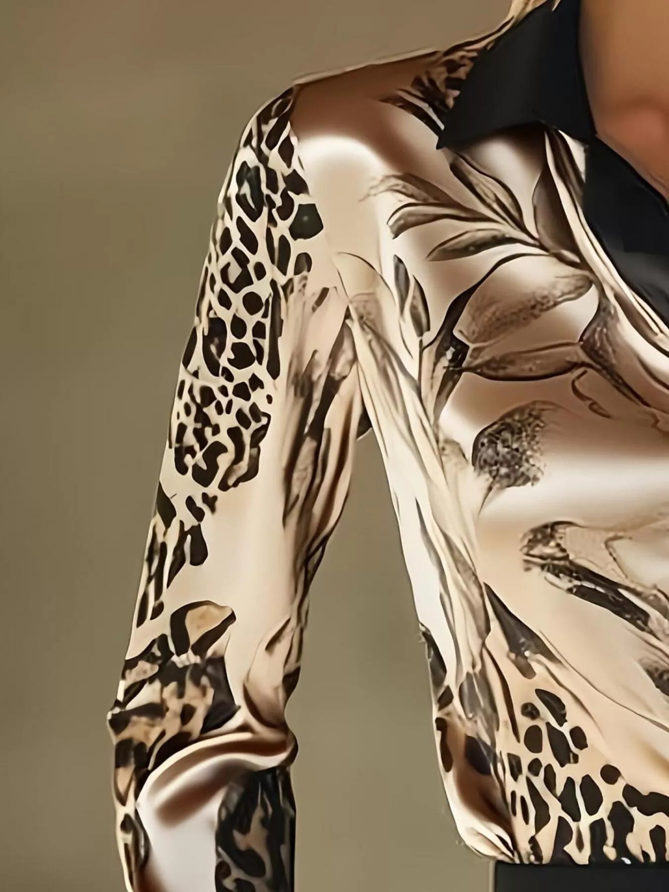 Close-up of a person wearing a shirt with a leopard print pattern on a plain background