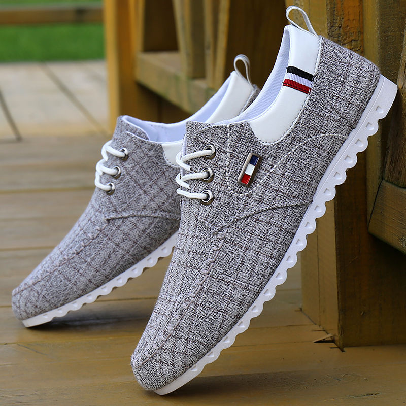 Gray casual shoes with white soles on a wooden floor