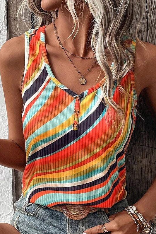 Person wearing a colorful striped tank top and denim shorts against a wooden wall.