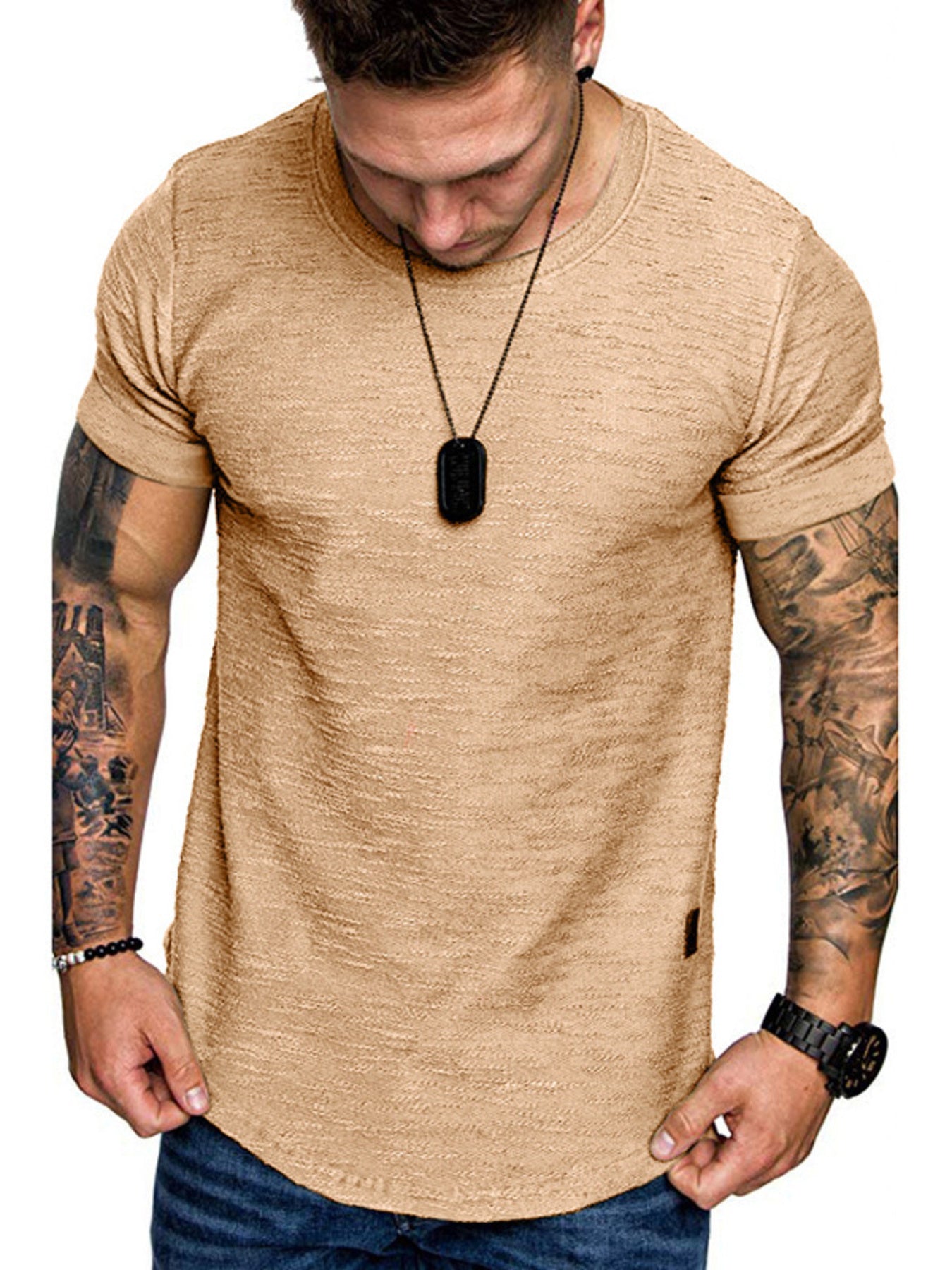 Man wearing a beige t-shirt with tattoos on arms, on a white background