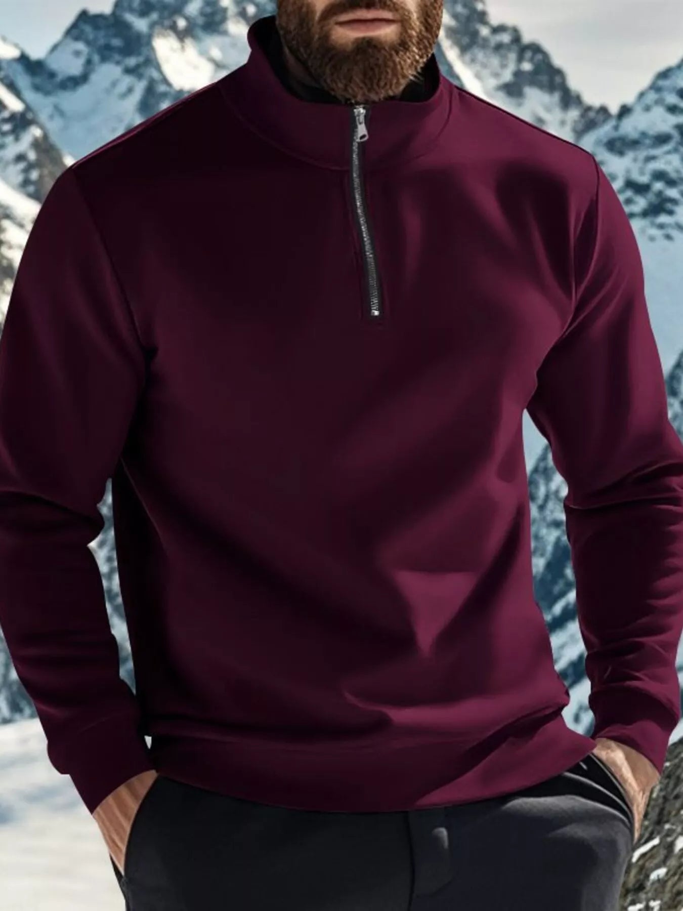 Person wearing a maroon pullover with a zipper in front of a mountainous landscape