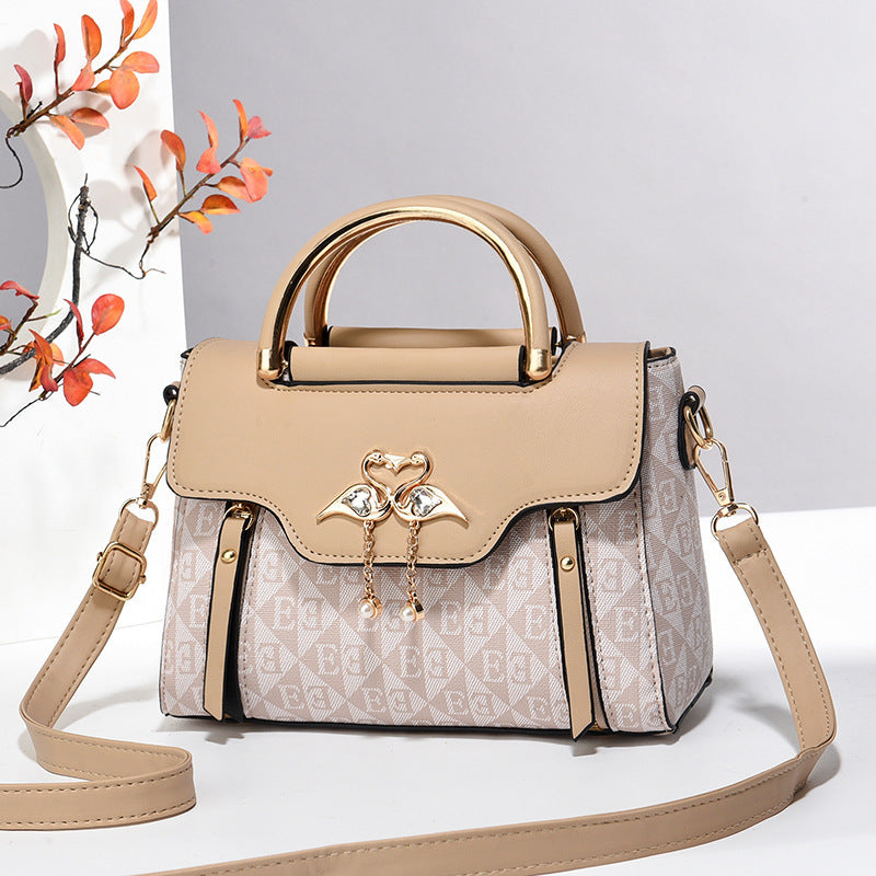 Beige handbag with gold accents on a light gray background