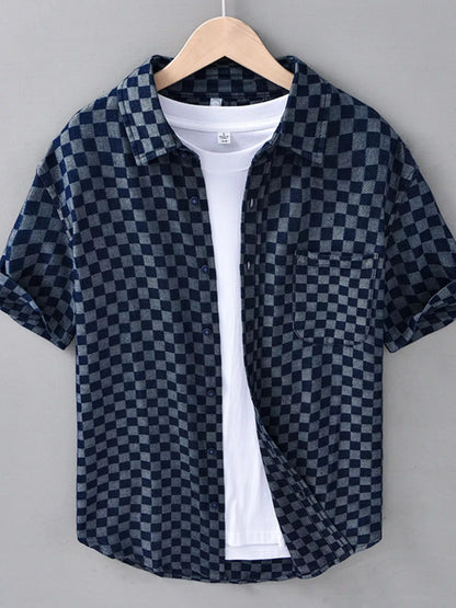 Checkered shirt on a hanger against a gray background