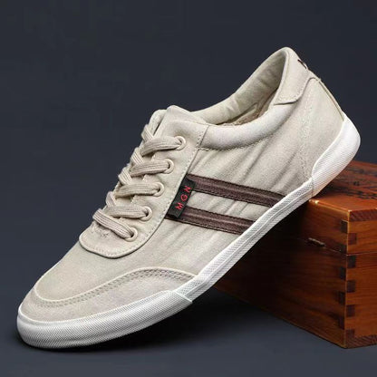 Beige sneaker with a brown stripe on a dark background