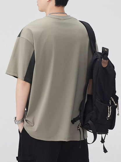 Person wearing a beige t-shirt and black backpack on a white background