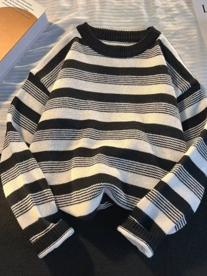 Black and white striped sweater on a dark surface