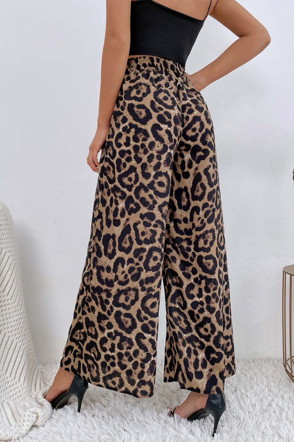 Person wearing leopard print pants with a plain background