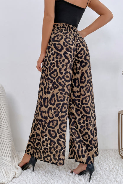 Person wearing leopard print pants with a plain background