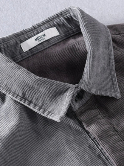 Close-up of a gray corduroy shirt with a collar and label on a light gray background
