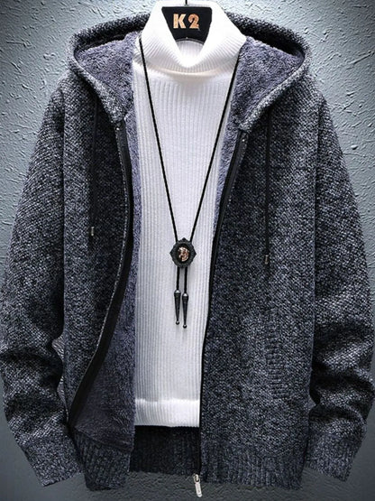 Gray hooded jacket over a white turtleneck with a necklace on a gray background