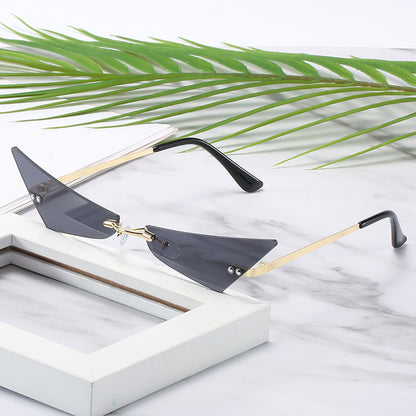 Sunglasses with gold and black frame on a marble surface with green leaves
