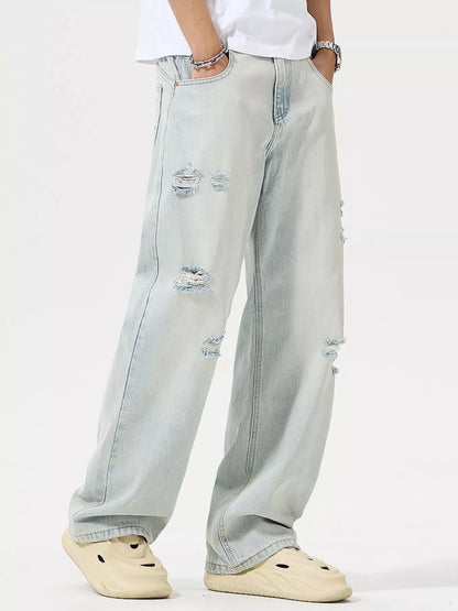 Light blue jeans with distressing details worn by a person on a white background