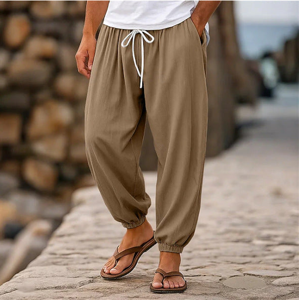 Person wearing beige pants and sandals standing on a stone path with a blurred background