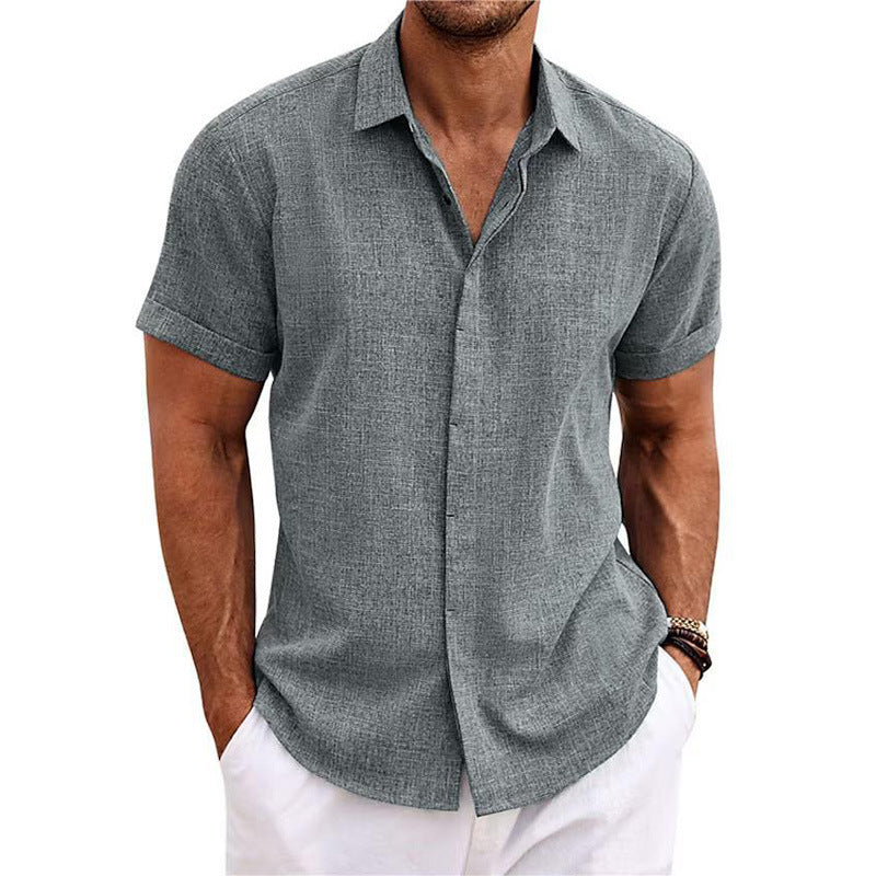 Man wearing a gray short-sleeve button-up shirt and white pants on a white background