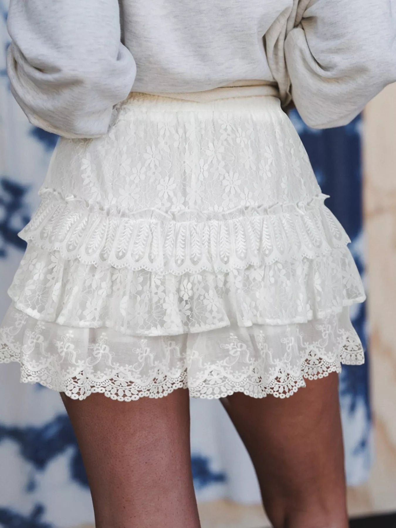 White lace skirt worn by a person with a blurred background