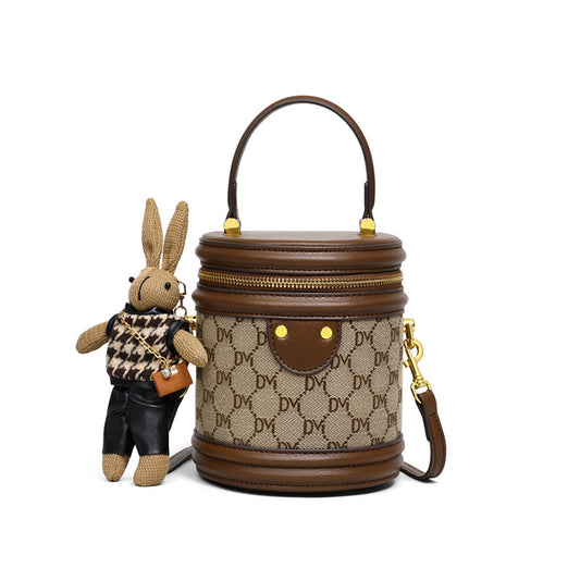 Bucket bag with decorative handle and plush rabbit toy on a white background