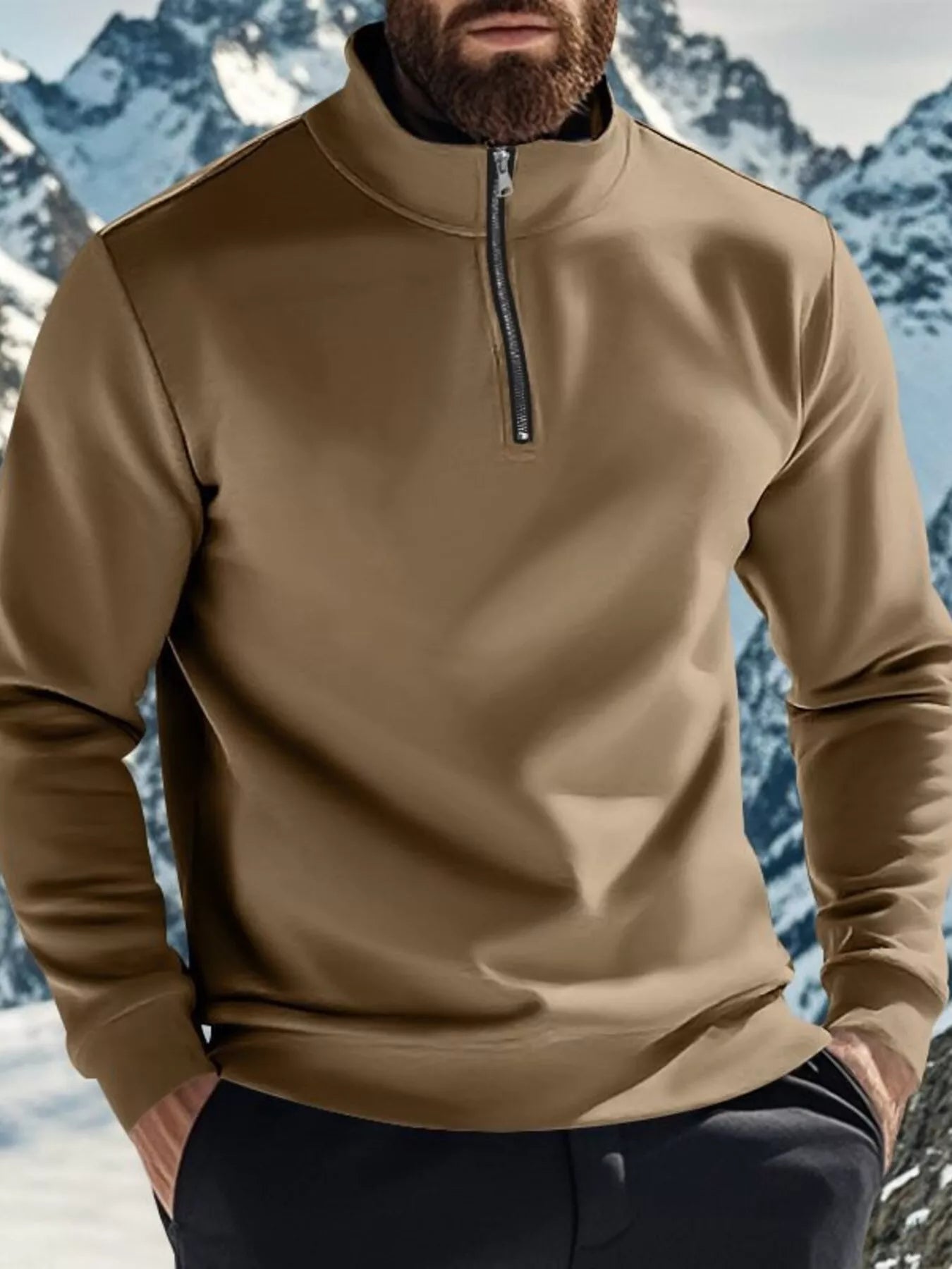 Person wearing a beige pullover with a mountainous background