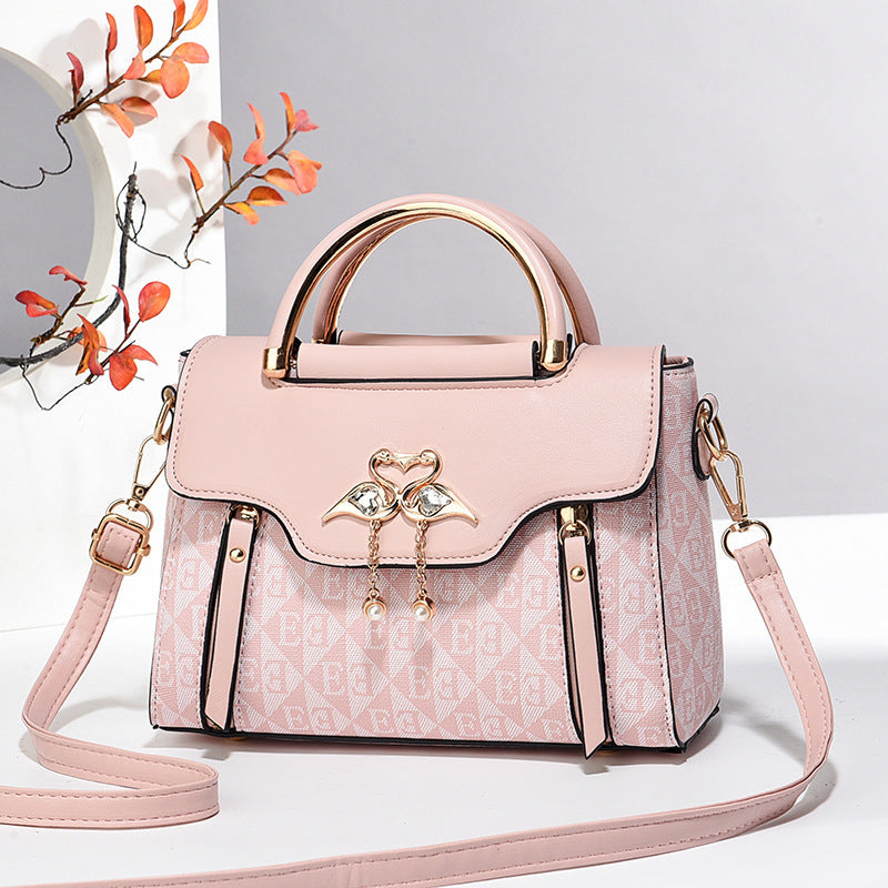 Pink handbag with gold accents on a light gray background