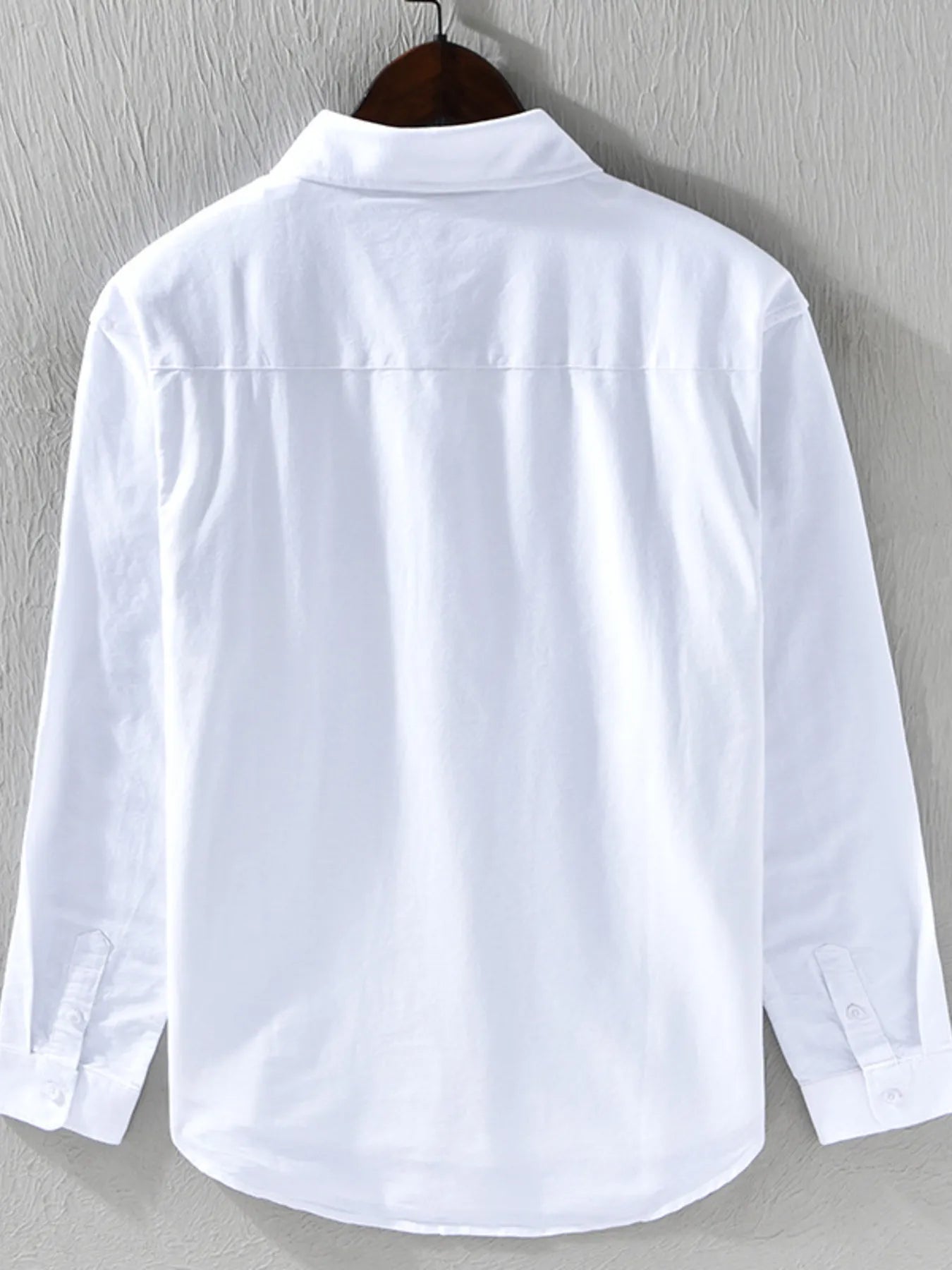 White shirt on a hanger against a gray background