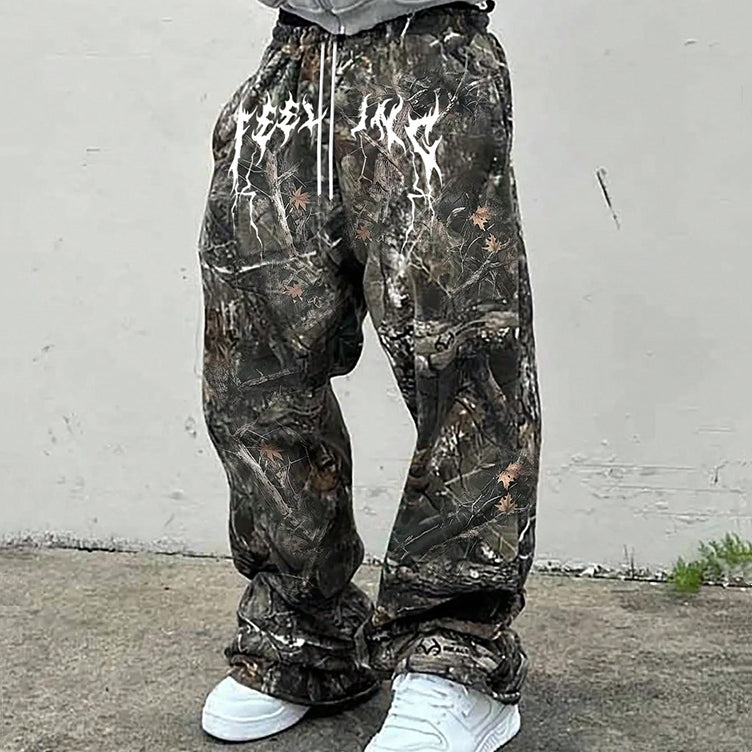 Person wearing camouflage sweat pants against a plain white wall.