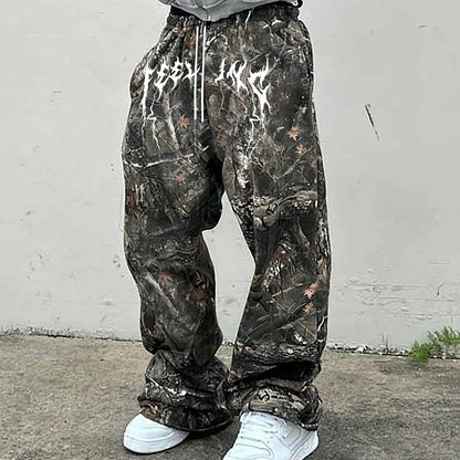 Person wearing camouflage sweat pants against a plain white wall.