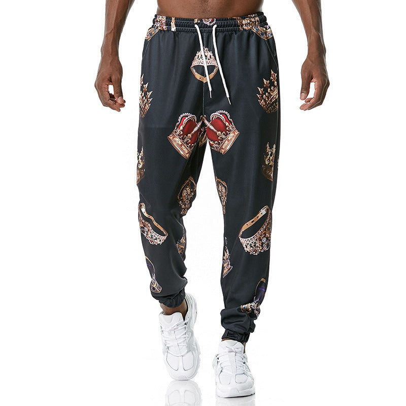 Black jogger pants with graphic designs worn by a person on a white background