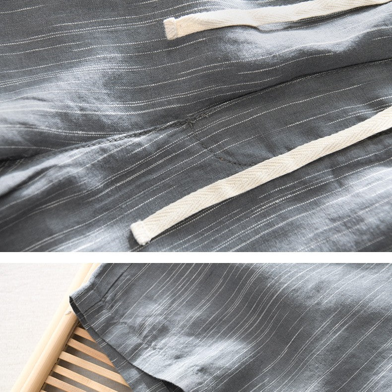 Close-up of gray fabric with white stripes and a wooden stick on a matching gray background.