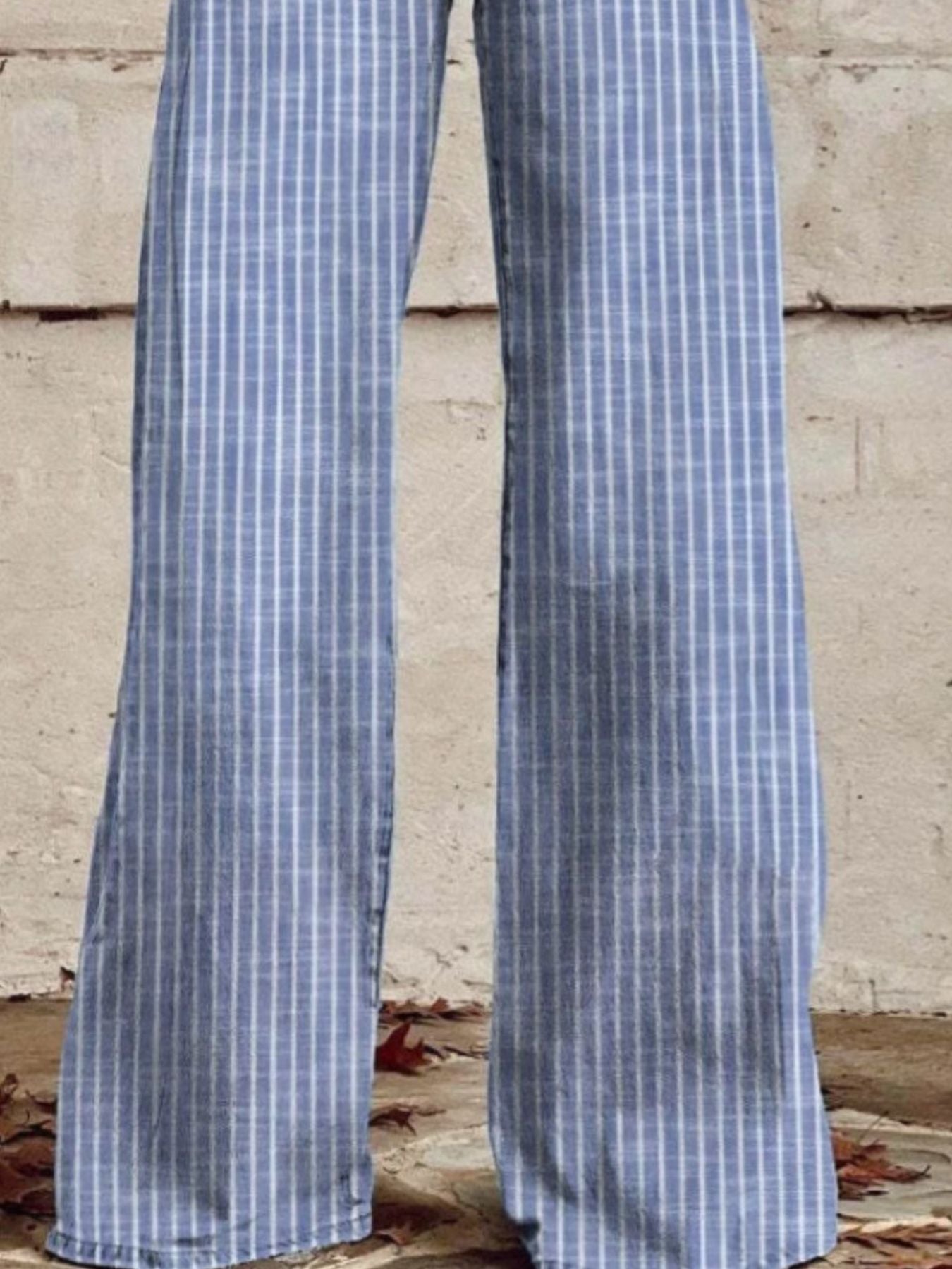 Blue and white checkered pants against a concrete wall.