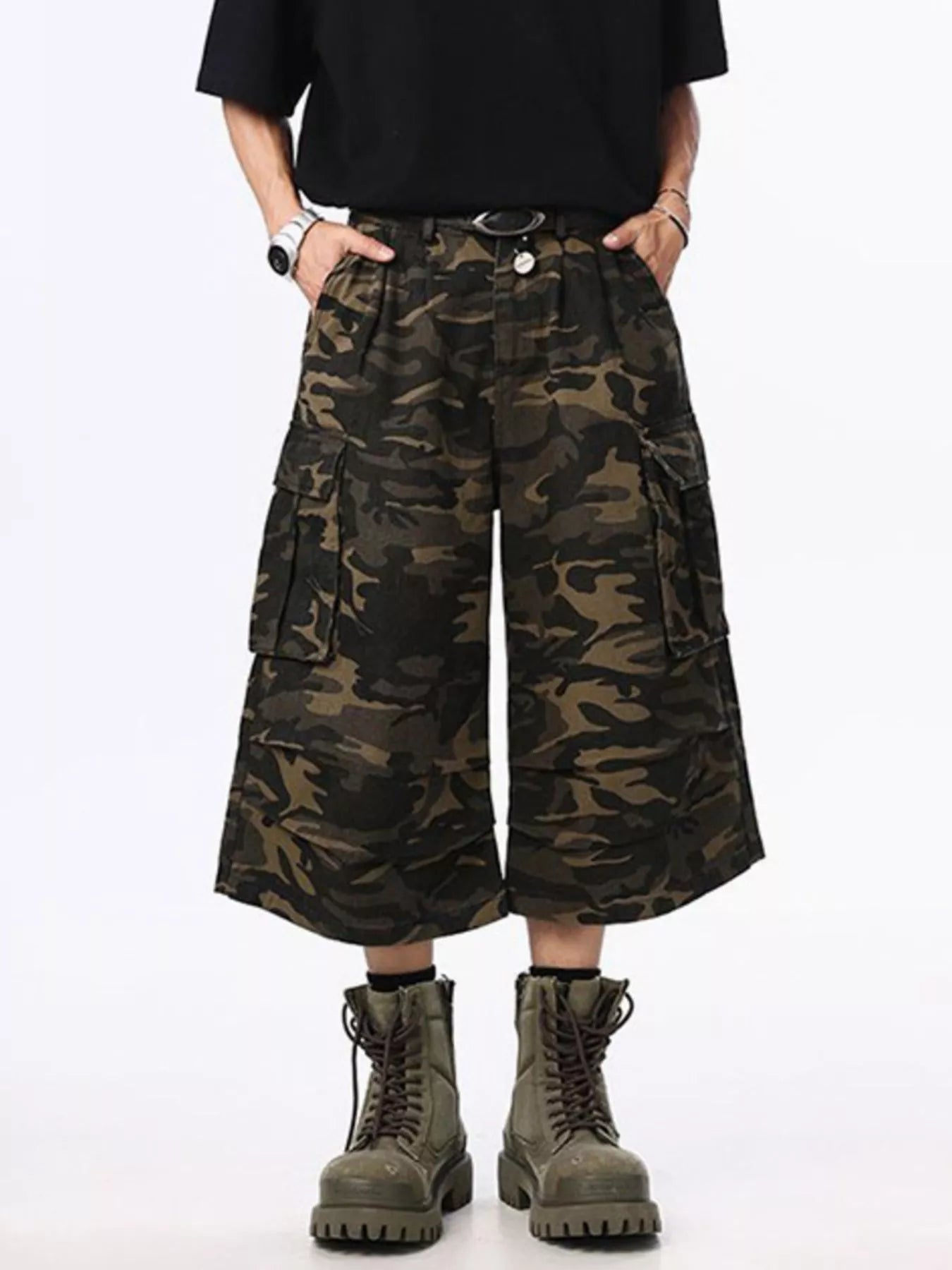 Person wearing camouflage cargo shorts and boots on a white background
