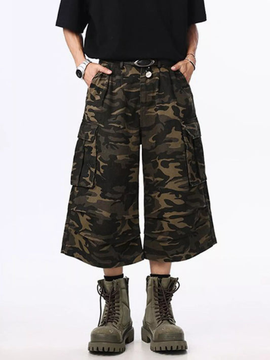 Person wearing camouflage cargo shorts and boots on a white background