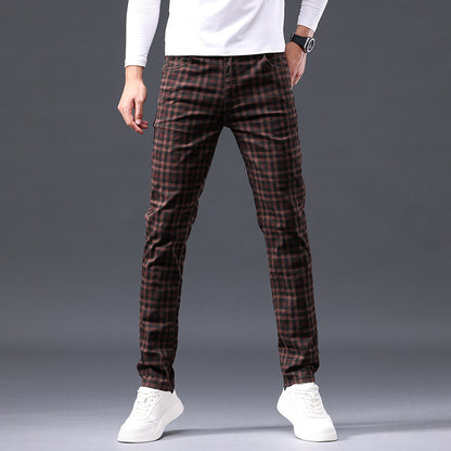 Person wearing brown plaid pants on a gray background