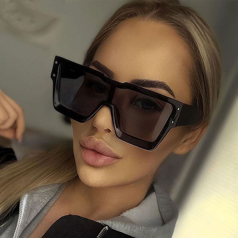 Woman wearing black sunglasses with a blurred background
