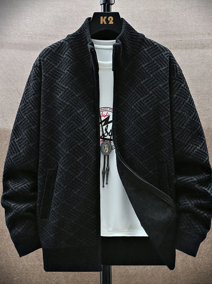 Black textured jacket on a hanger with a white shirt underneath against a neutral background