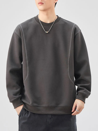 Person wearing a dark gray sweatshirt on a light gray background