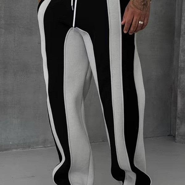 Person wearing black and white striped pants with a plain background